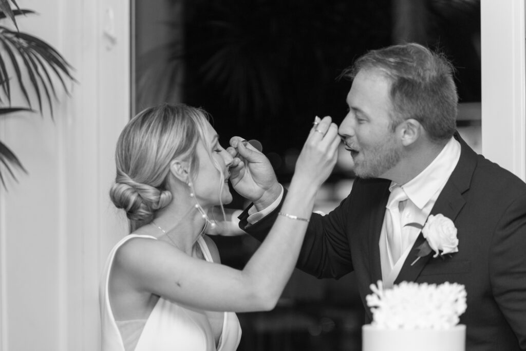 Cake cutting between bride and groom, feeding eachother during their wedding reception at the Pelican Club in Jupiter, Florida.